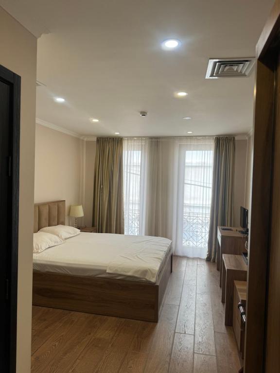 une chambre avec un lit, un bureau et des fenêtres dans l'établissement Hotel-apartment in the centre, à Tbilissi
