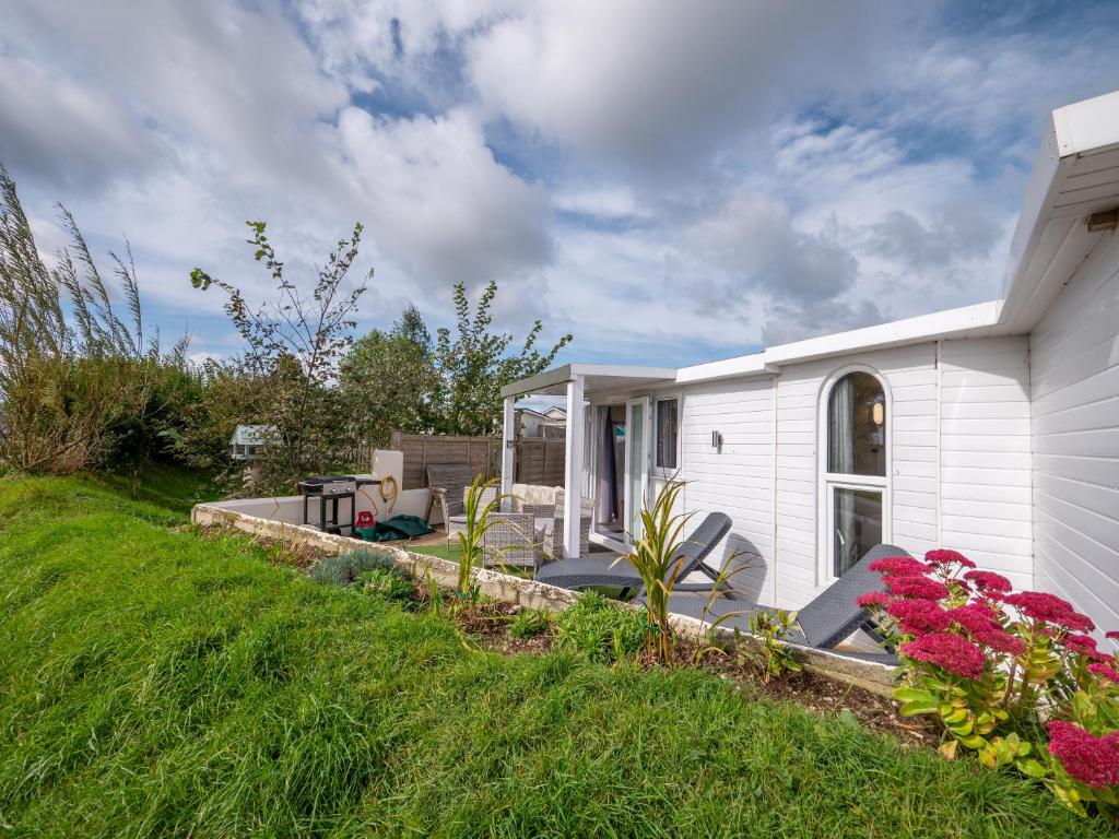 Casa blanca con patio y flores en Cosy Cabin for Two with Lovely Countryside Views, Near Kingsbridge, en Churchstow