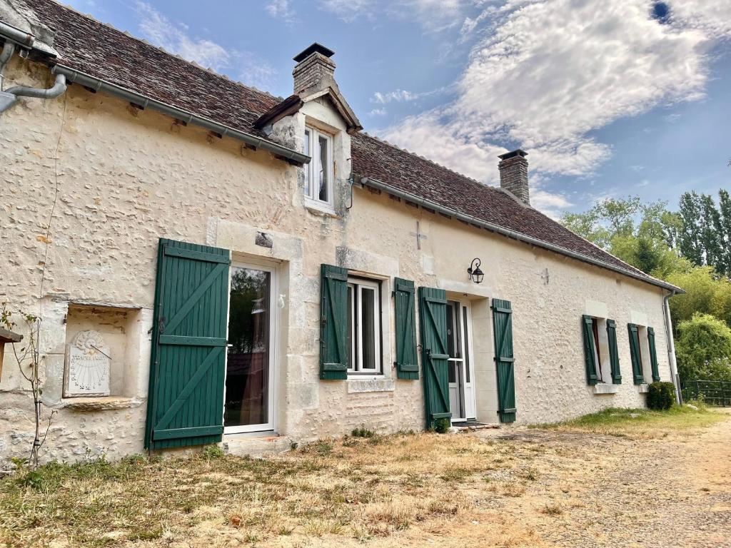 un vieux bâtiment blanc avec des volets verts dans l'établissement Voilà Le Logat - Chambres & Gîtes, à Sainte-Gemme