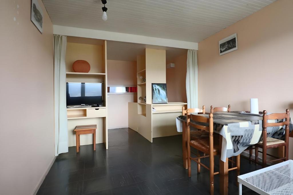 Una cocina y un comedor con una mesa y un televisor. en Sapins A5 - Résidence Super Murat, en Murat-le-Quaire