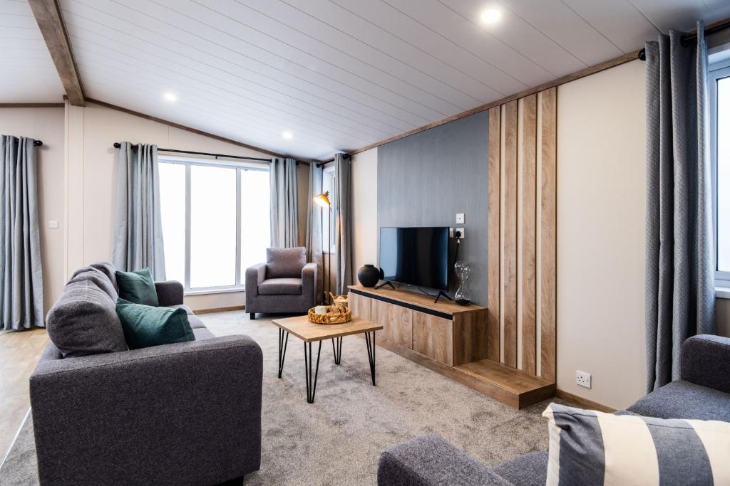 a living room with two couches and a tv at Hot Tub Lodge, Victory Liberte 104 in St. Andrews