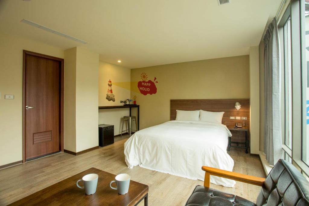 Habitación de hotel con cama y sofá en Just Live Inn-Keelung en Keelung
