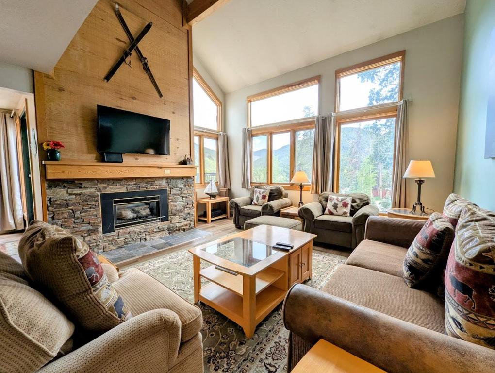 a living room with couches and a fireplace at Quicksilver 1607 by SummitCove Lodging in Keystone