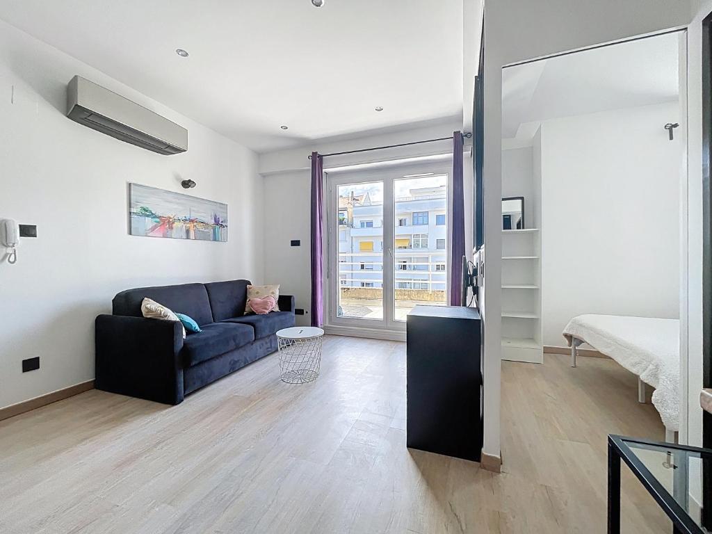 a living room with a couch and a bed and a window at Strasbourg Centre et Parlement in Strasbourg