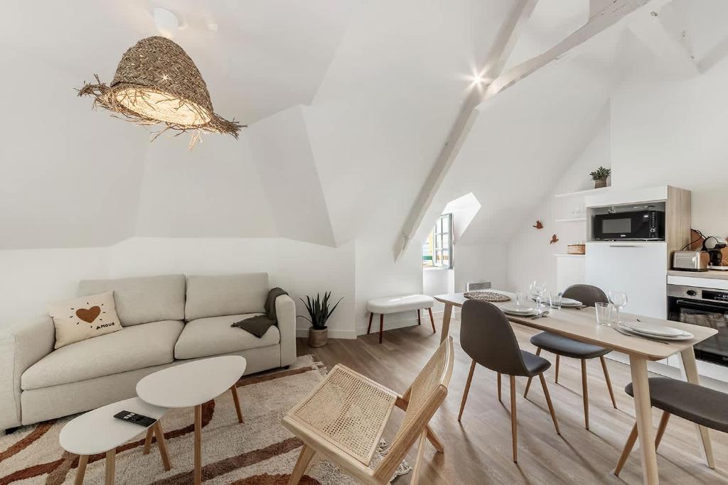 Una sala de estar con un sofá, una mesa y sillas. en Bord de l'eau 6 - Sea view - 3 people, en Cancale