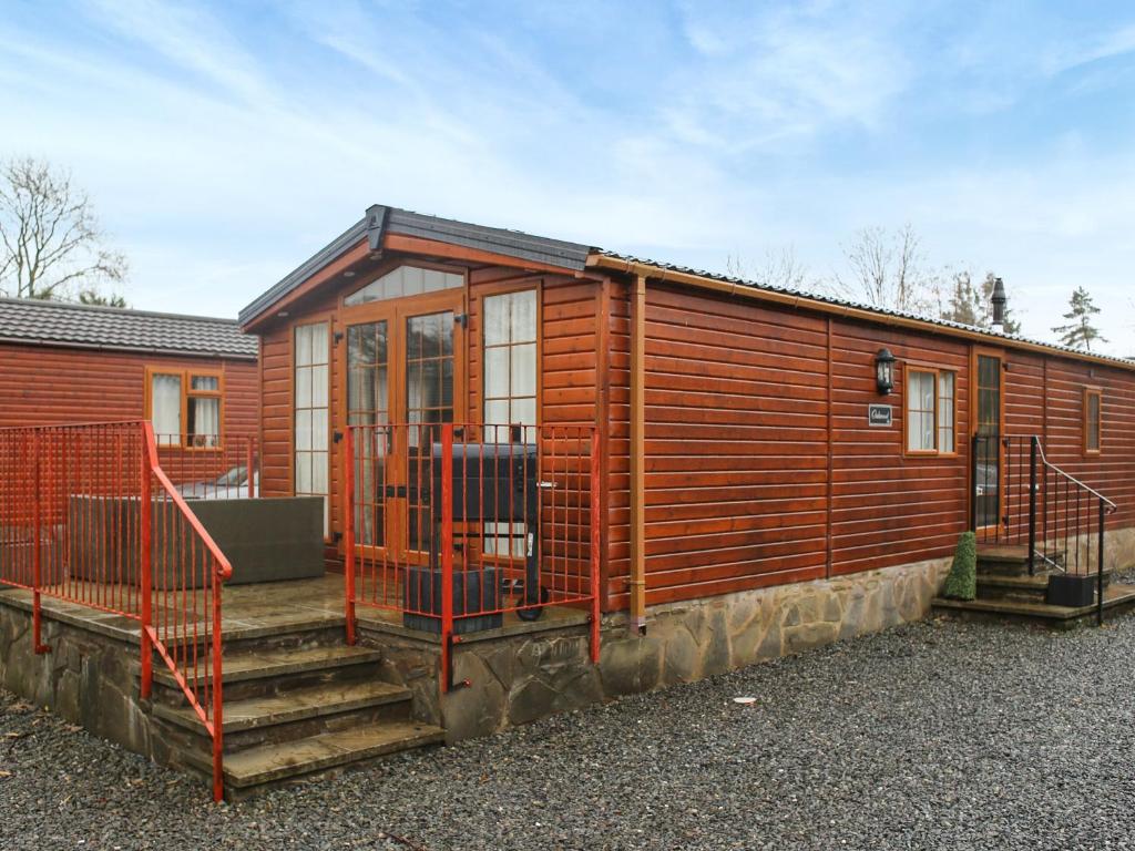 een houten huis met een trap daarheen bij Craig Rossie Lodge in Auchterarder