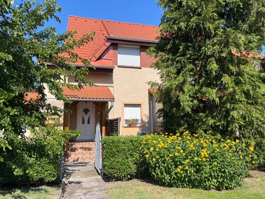 a house with a gate and flowers in front of it at Apartment Pajtas 1 by Interhome in Balatonfenyves