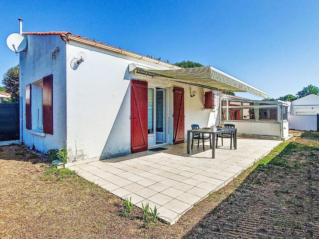 una pequeña casa con una mesa delante en Holiday Home La Coti by Interhome, en Saint-Pierre-dʼOléron