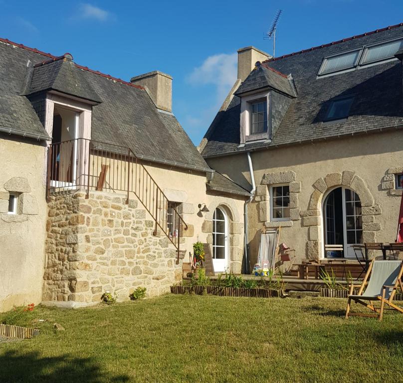 an old stone house with a patio and a yard at La Chouetterie in Binic