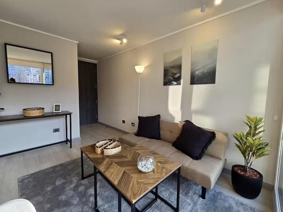una sala de estar con un sofá y una mesa en Modernos departamentos, en Santiago