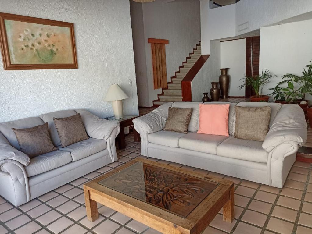 a living room with two couches and a coffee table at Cancún Villa Marina Blanca in Cedro