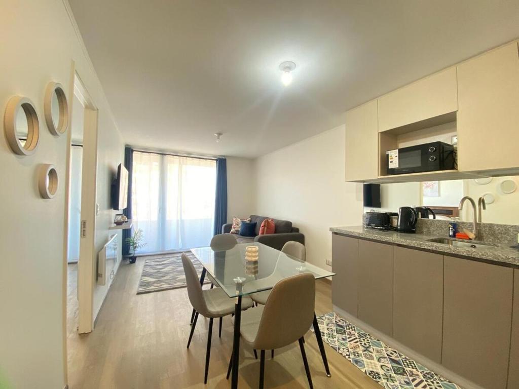 a kitchen and living room with a table and chairs at Apart Total Centro Belmonte in Temuco