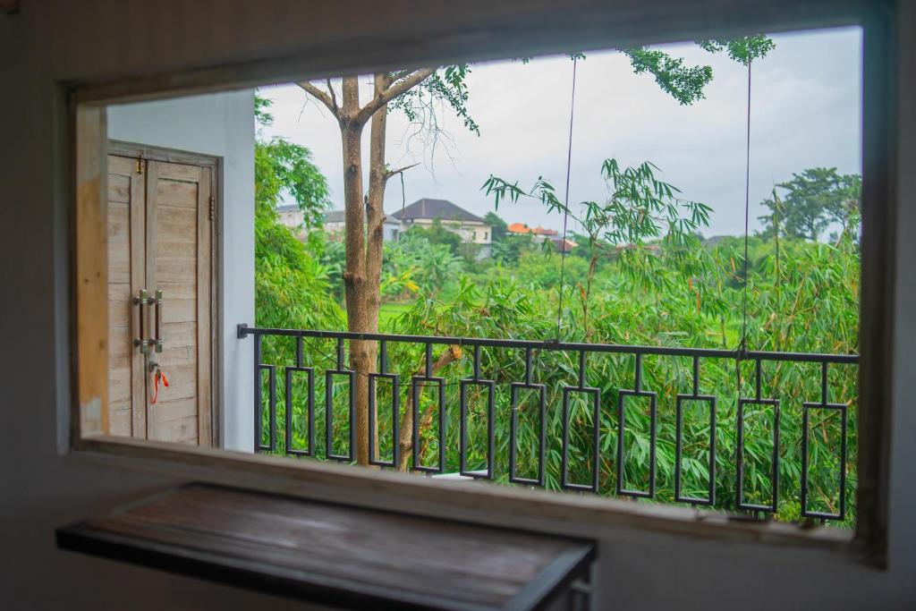 a window view of a garden from a balcony at The Sri Loft in Dalung