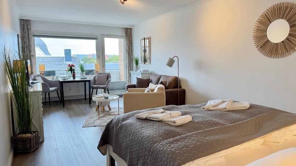 a bedroom with a bed and a living room at Strand-Gut, 12-29 in Westerland (Sylt)