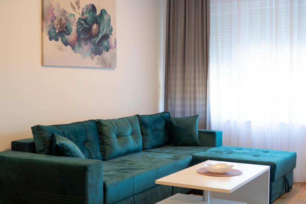 a living room with a blue couch and a table at Apartman Petra Trebinje in Trebinje