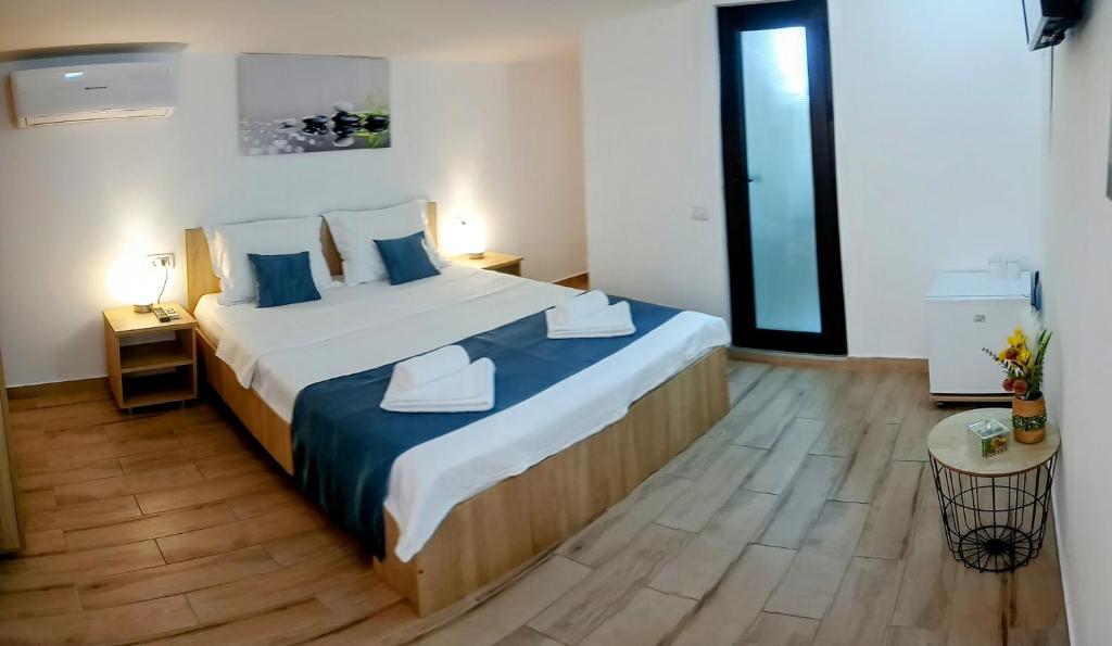 a bedroom with a large bed with blue pillows at Vila Lorena in Mangalia