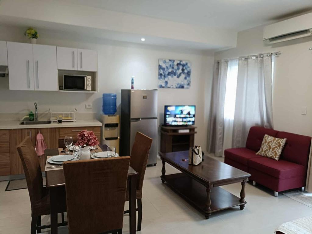 a kitchen and living room with a table and a couch at Cozy 2bedrooms Matina Enclaves condo in Davao City