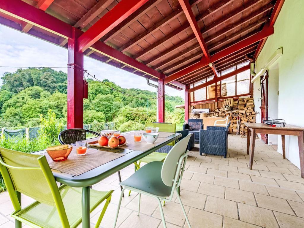 Un patio al aire libre con mesa y sillas. en Apartment Iratzea by Interhome, en Saint-Pée-sur-Nivelle