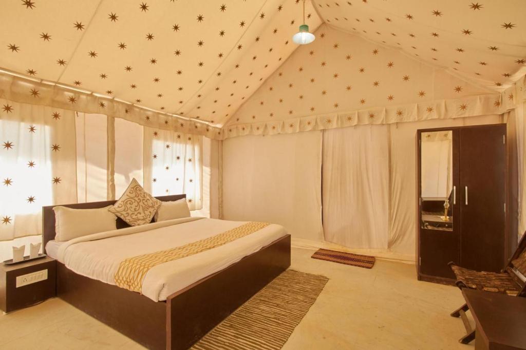 a bedroom with a bed in a room with stars on the ceiling at Savi Camps Jaisalmer in Sām