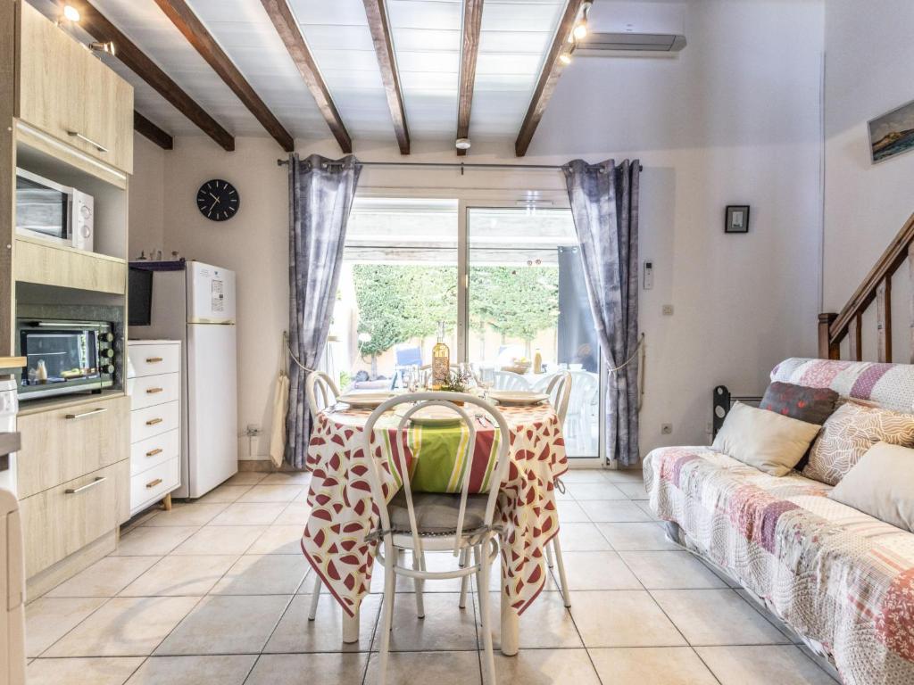 a kitchen and living room with a table and a couch at Holiday Home Hacienda Beach II-7 by Interhome in Agde