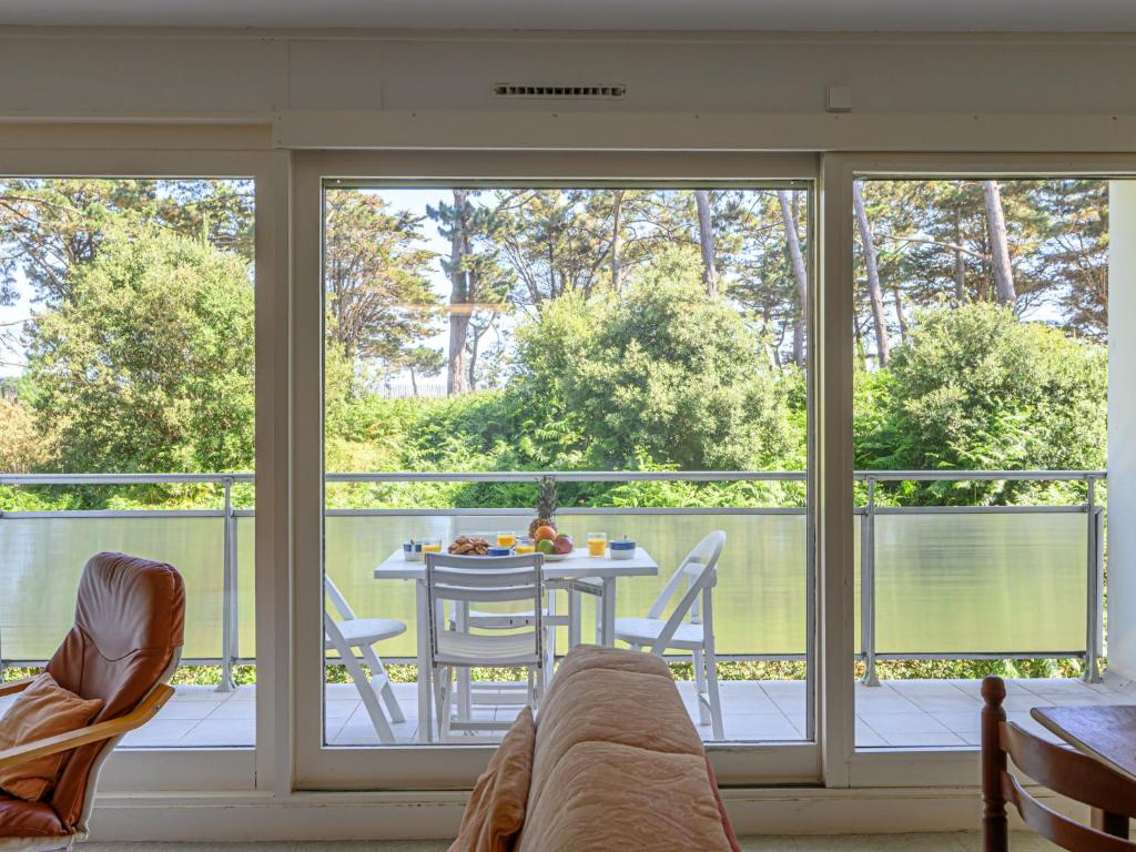 a screened in porch with a table and chairs at Apartment Men Er Bellec-4 by Interhome in Saint-Philibert