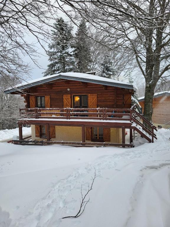 Chalet de montagne familial في Montferrier: كابينة خشبية في الثلج مغطاة بالثلج