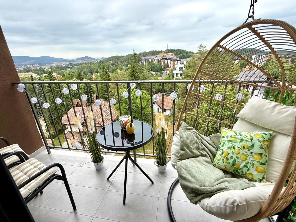 a balcony with a chair and a table with a view at Apartman Njegoš Lux Titova vila in Palisad