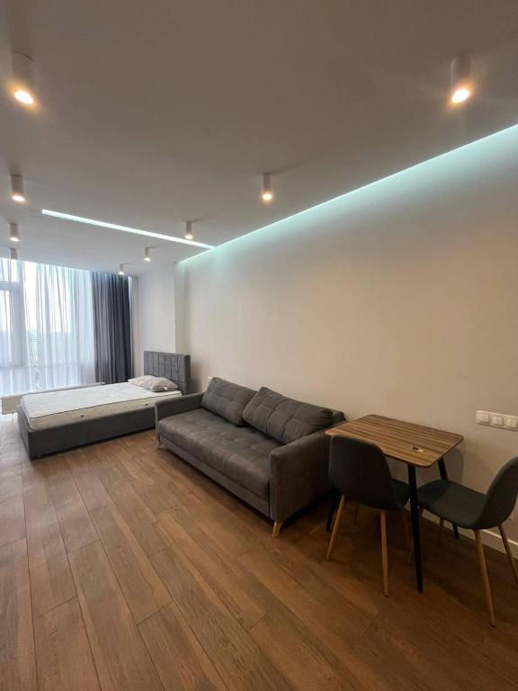 a living room with a couch and a table and a bed at Arcadia Studio 238-1 in Odesa