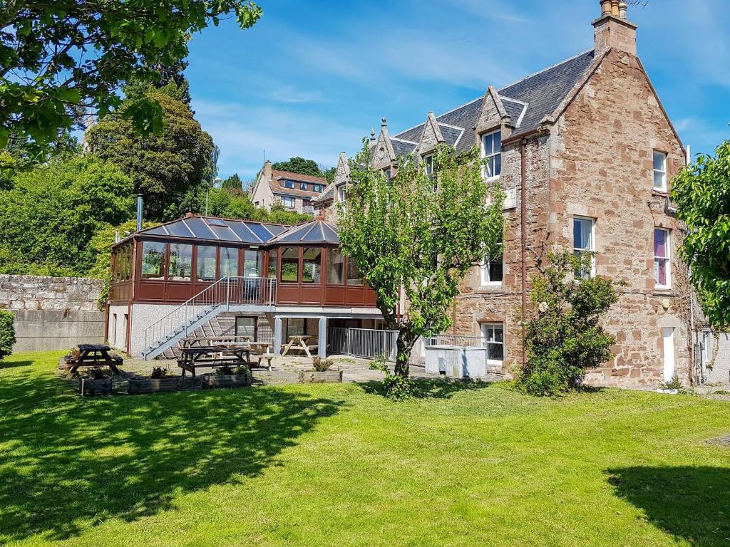 a large brick building with a table in a yard at The Dolphin - Uk31004 in Avoch