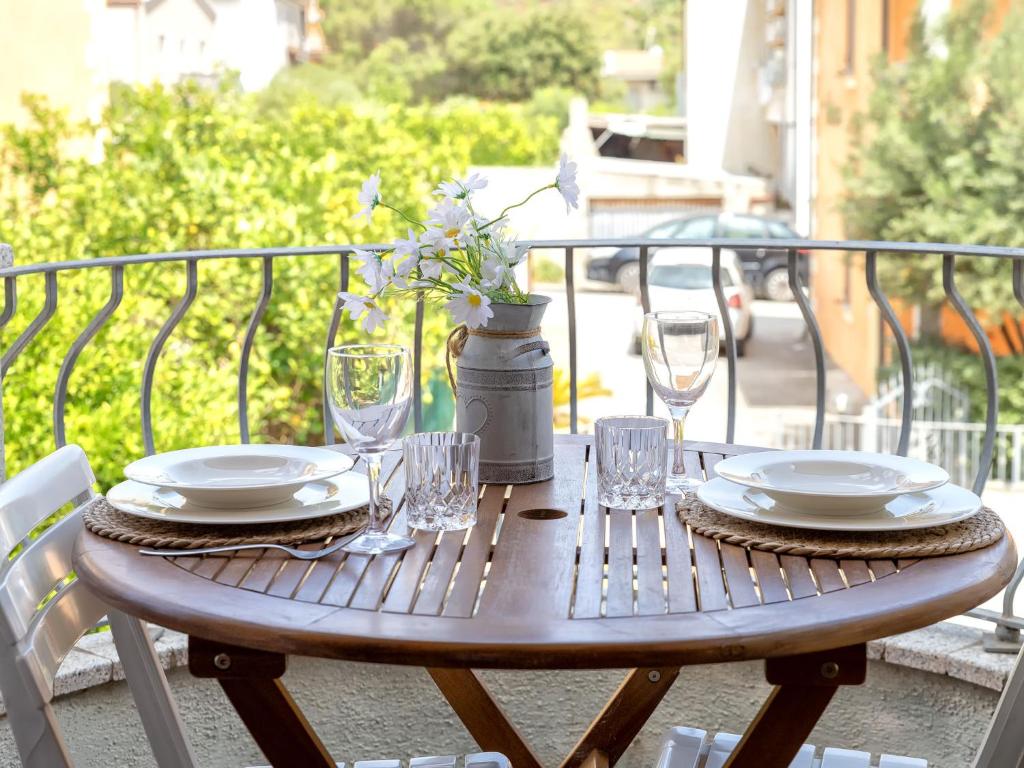 a wooden table with plates and glasses on a balcony at Apartment Del Colle by Interhome in Viddalba