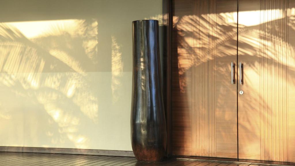 a glass door with a vase next to a wall at InterContinental Mauritius Resort Balaclava Fort by IHG in Balaclava