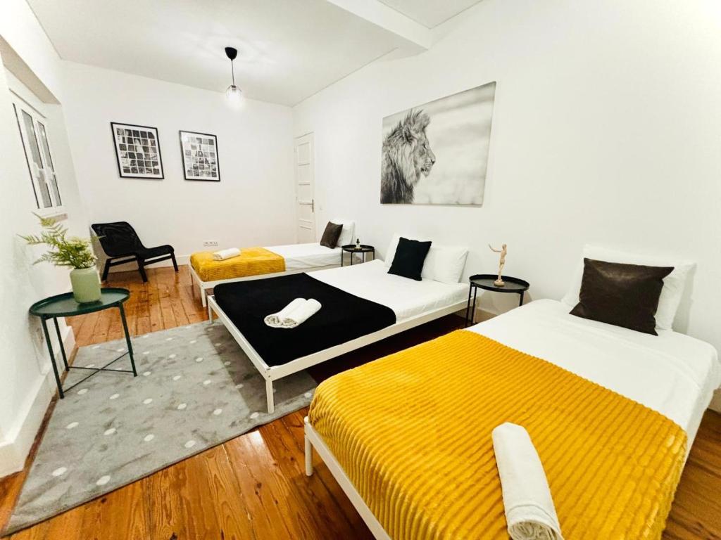 a bedroom with two beds and a couch at Luxury rooms, Lisbon city centre in Lisbon