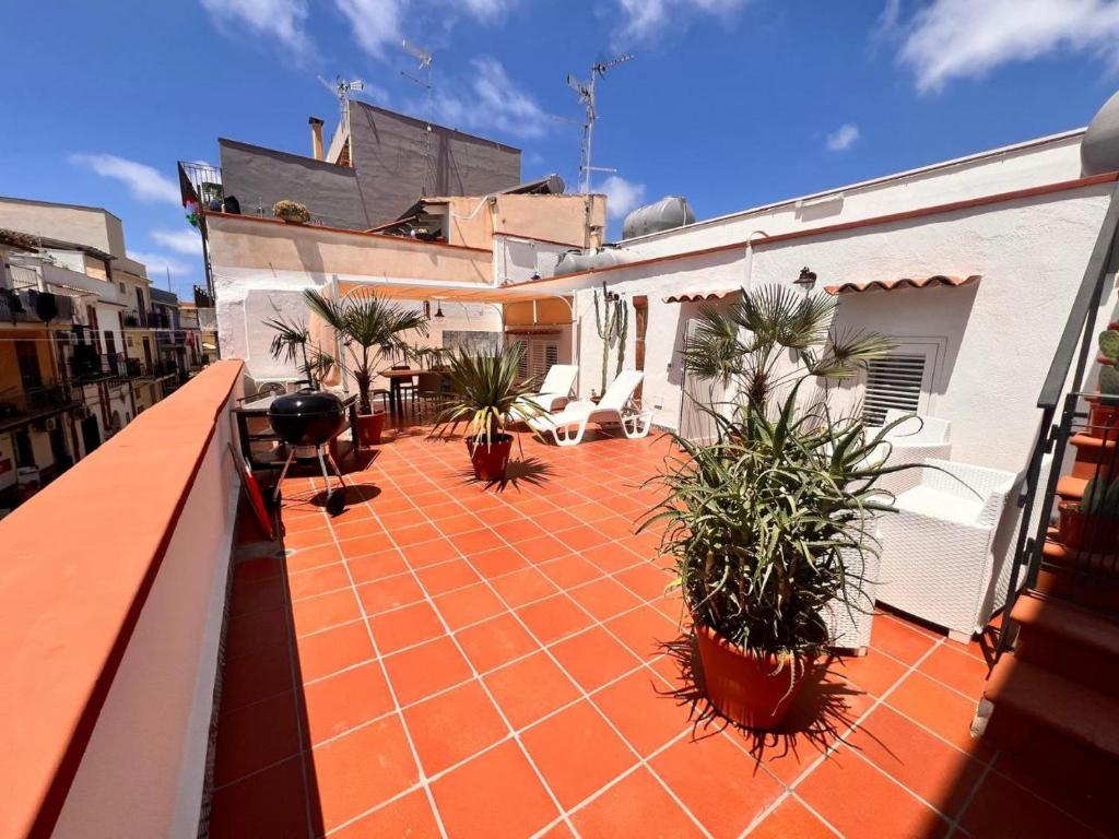 un balcón con plantas y sillas en un edificio en Casa di Oben, en Terrasini