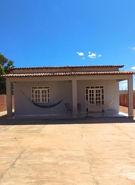 a small white house with a roof at Casa aconchegante in São Raimundo Nonato