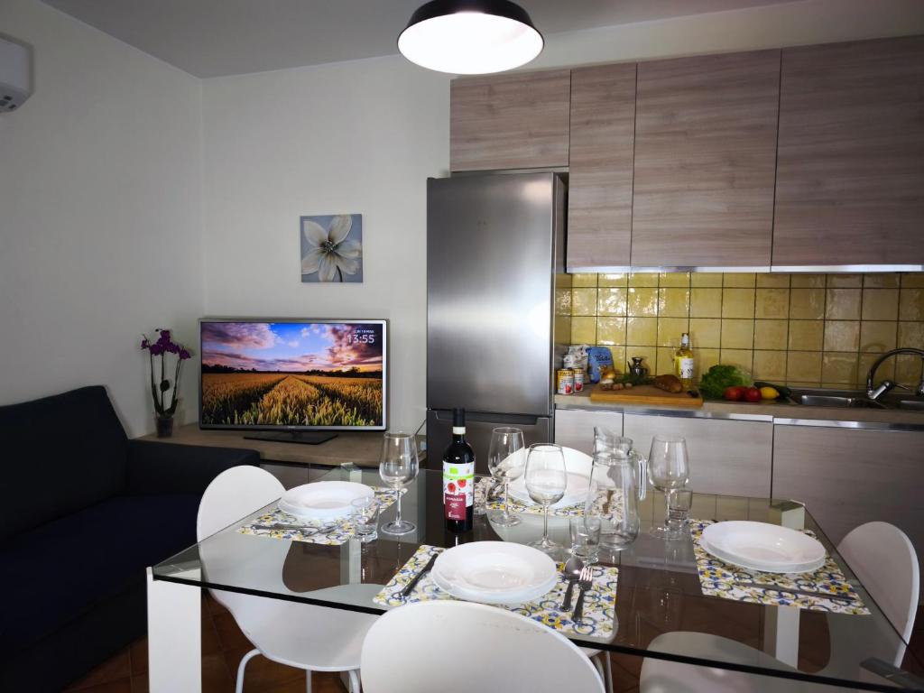 a kitchen with a dining room table with white chairs at La Porta della COSTIERA in Cava deʼ Tirreni