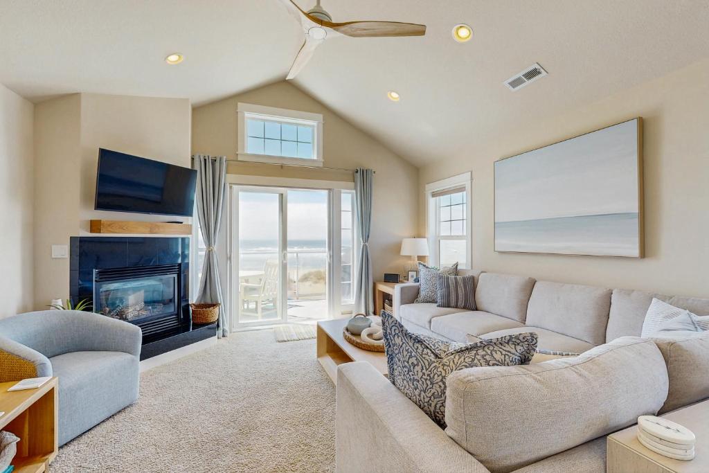 a living room with a couch and a fireplace at Alluvial Shores in Rockaway Beach