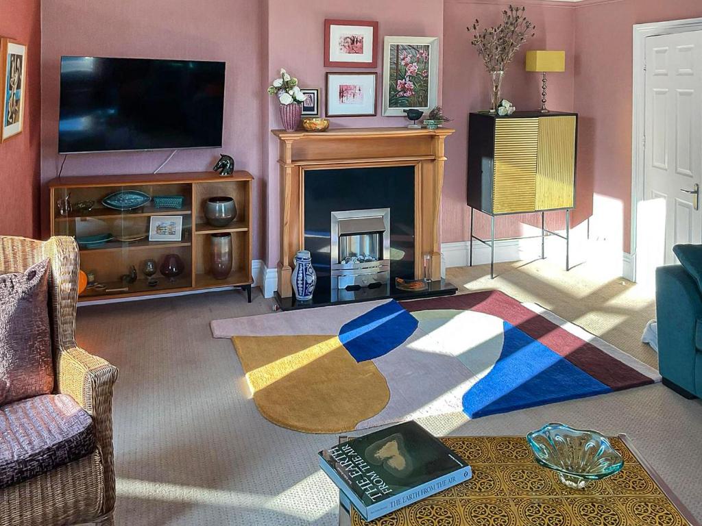 a living room with a fireplace and a television at The Artists Retreat in Whitby