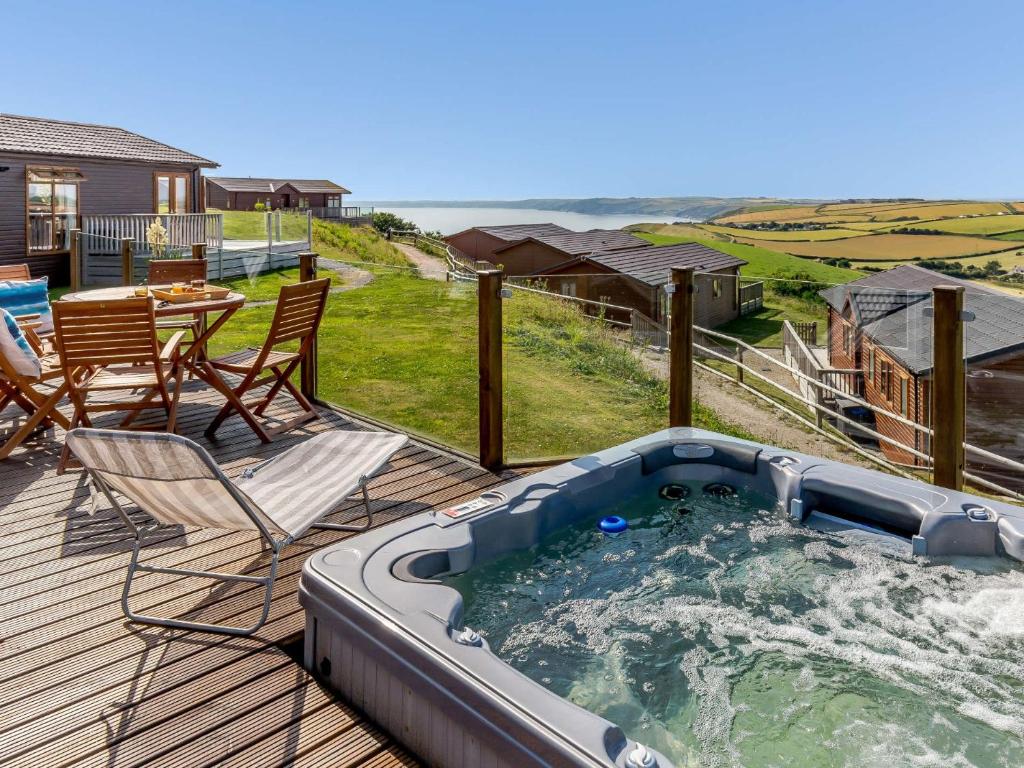 a hot tub on a deck with a table and chairs at 3 Bed in Millbrook 83792 in Millbrook