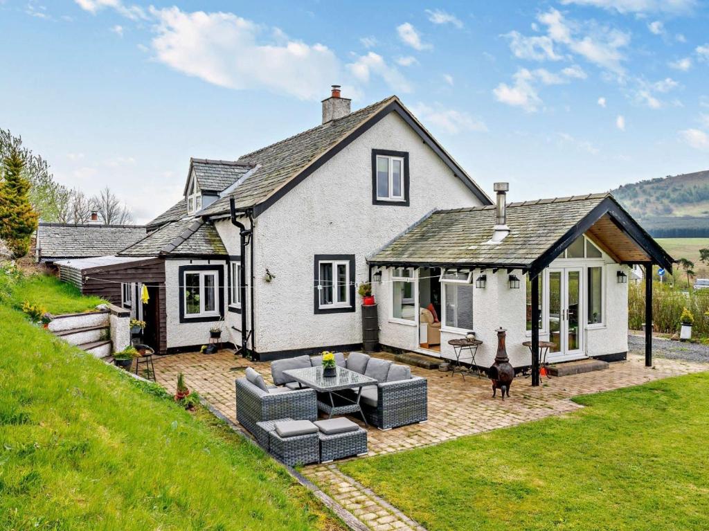 a white house with a patio and a backyard at 4 Bed in Troutbeck nr Ullswater SZ256 in Troutbeck