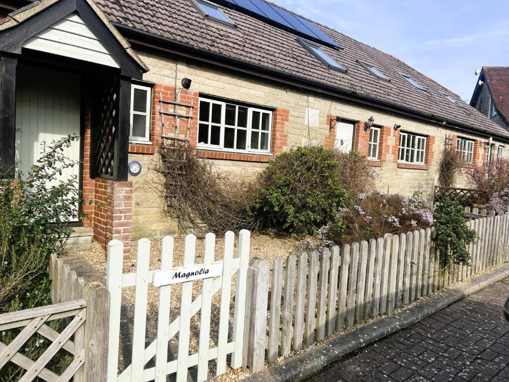 ein weißer Gartenzaun vor einem Haus in der Unterkunft 2 Bed in Godshill IC078 in Godshill