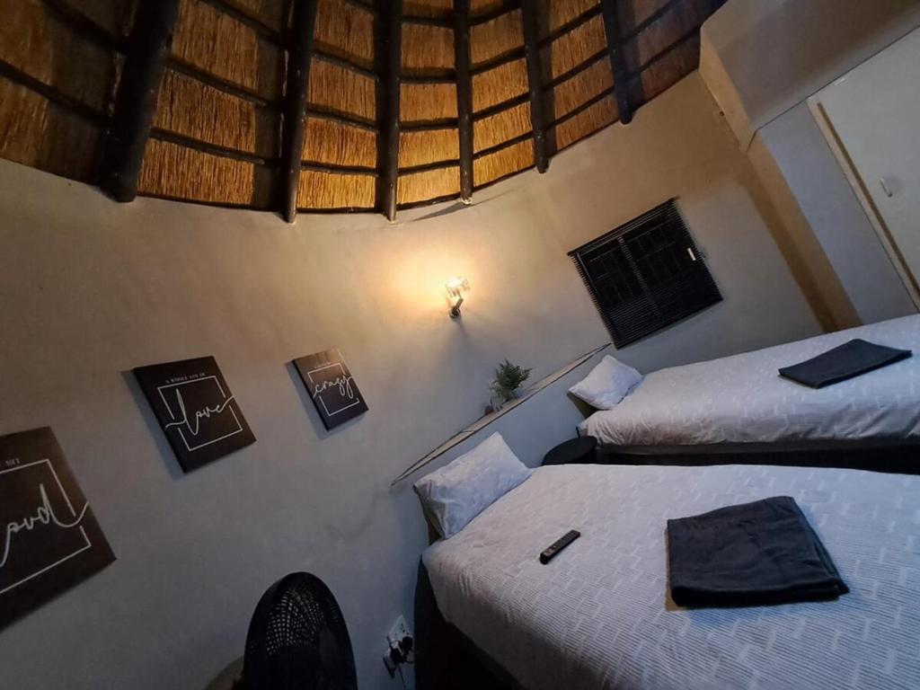 a room with two beds and two pictures on the wall at Afpak in Barberton
