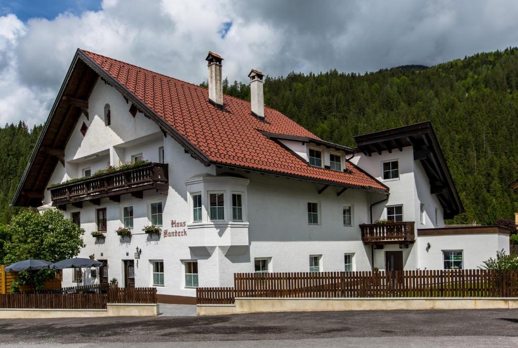a large white building with a red roof at Haus Sandeck in Ehrwald