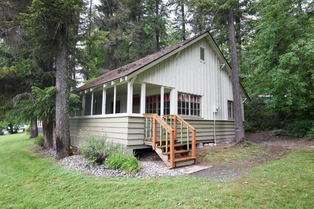 een klein wit gebouw met een veranda en een trap bij Wilderness West Resort Cabin 6 in Colville