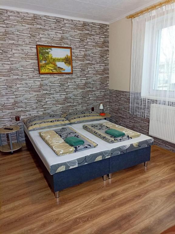 a large bed in a room with a brick wall at Abturist penzion in Štúrovo