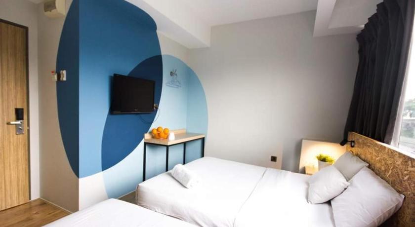 a bedroom with a white bed and a blue wall at I LUX I-Hotel Kuala Lumpur in Kuala Lumpur