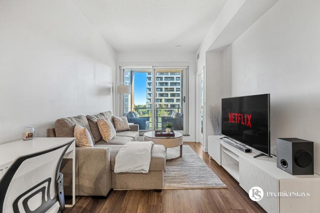 a living room with a couch and a tv at Luxury Spacious 2 Bedroom Apartment at The Radius in Calgary