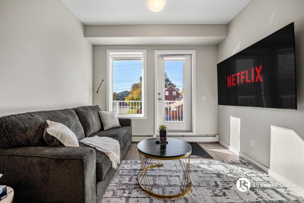 ein Wohnzimmer mit Sofa und Tisch in der Unterkunft Luxury Getaway in Inglewood with 2 Bedrooms Sofa Bed and Heated Underground Parking in Calgary