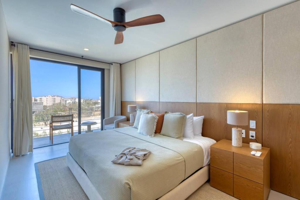 a bedroom with a large bed with a ceiling fan at New and Elegant 4Bedroom House Steps from the Beach in Cabo San Lucas