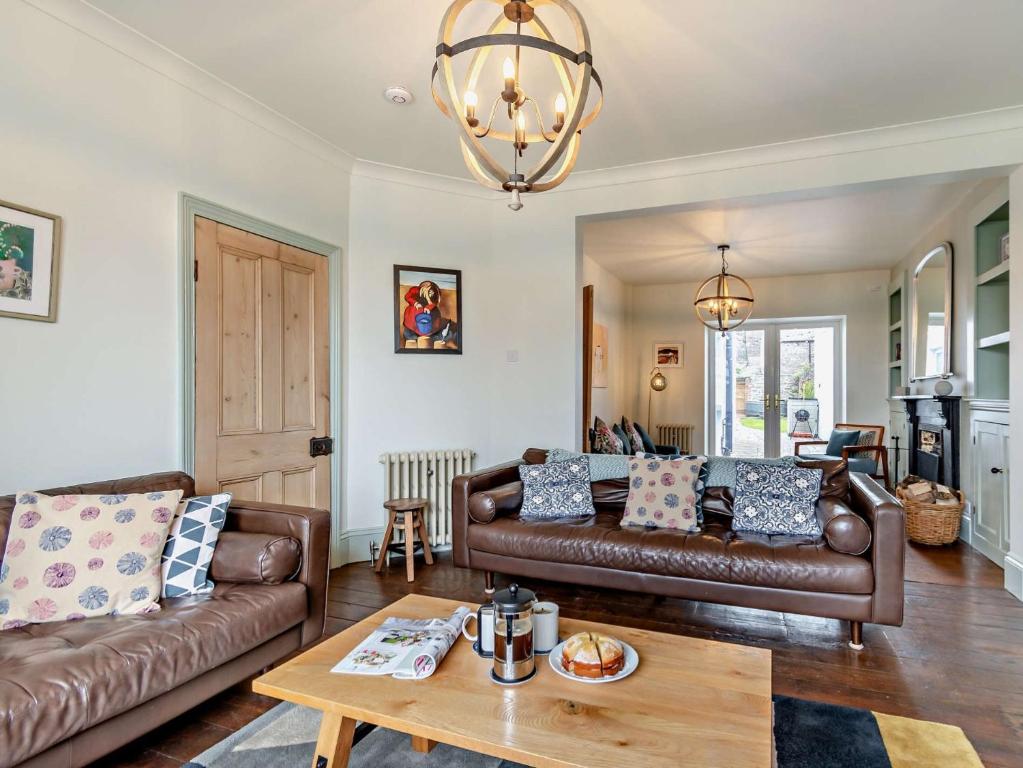 una sala de estar con 2 sofás de cuero marrón y una mesa. en 4 Bed in Tenby FB193, en Tenby
