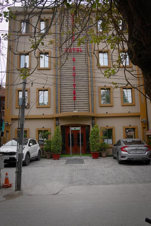 a building with cars parked in front of it at Neshaz Hotel & Suites in Lahore